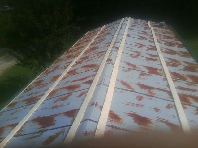 Rusted metal roof panels with new wood purlins before replacement — Storm Damage Roof Repair in Keezletown by Roofing Brothers