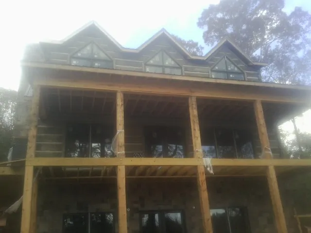 Dormers and porch framing on a large log home under construction — Roof Coating work by our crew in Keezletown