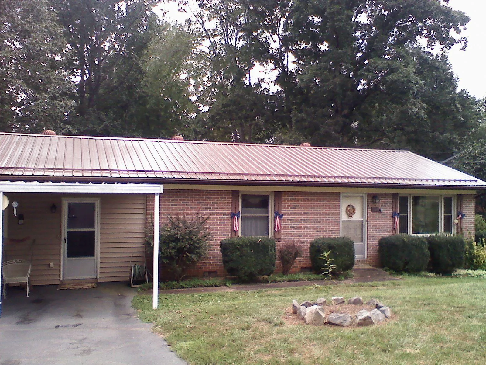 Bronze metal roof and carport on a brick ranch home — Roof Repair work by our crew in Keezletown